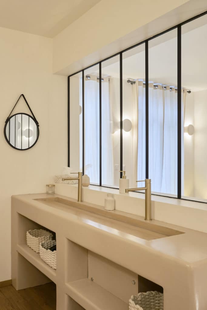 Vasque design avec miroir rond et fenêtre dans le cottage scandinave