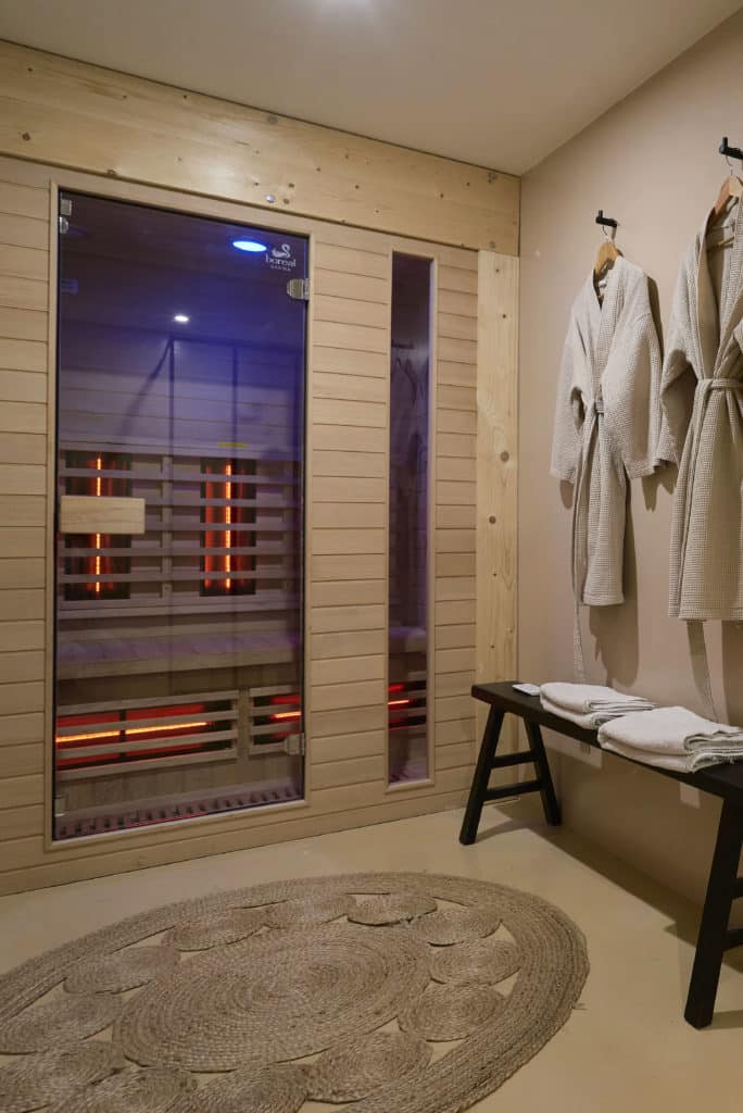 Sauna privatif avec lumière tamisée et peignoirs au cottage scandinave