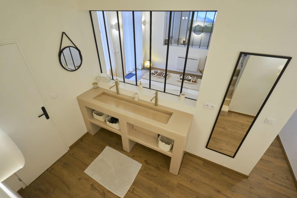 Salle de bain du cottage scandinave avec miroir rond et grande vasque moderne