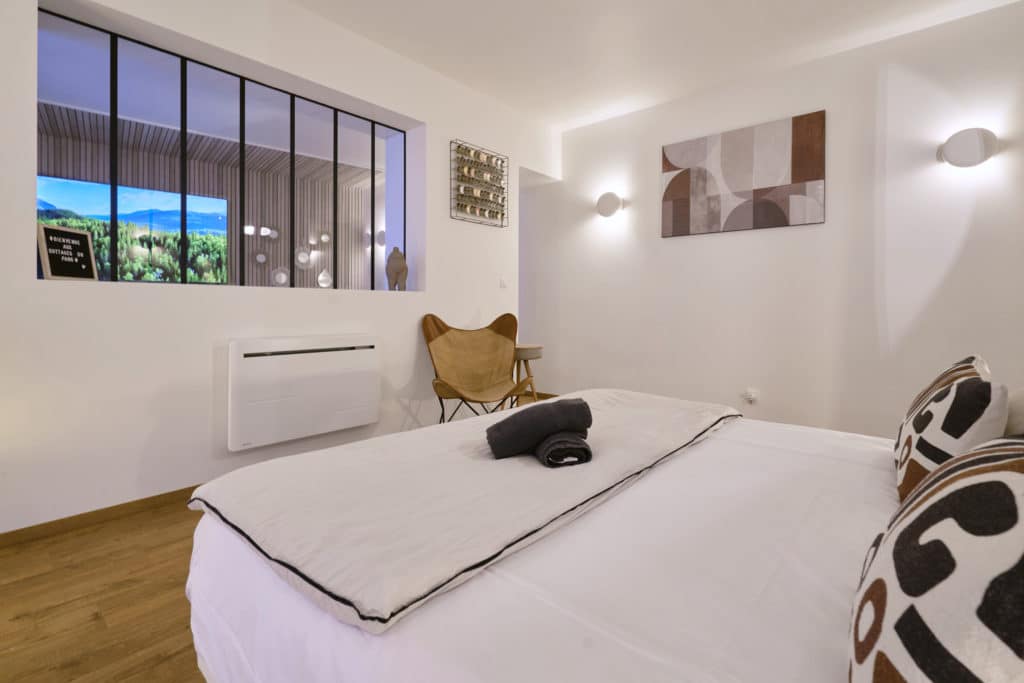 Chambre du cottage scandinave avec lit double et grande verrière