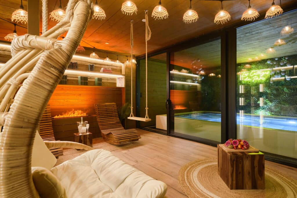 Espace détente du cottage scandinave avec fauteuil suspendu et vue extérieure