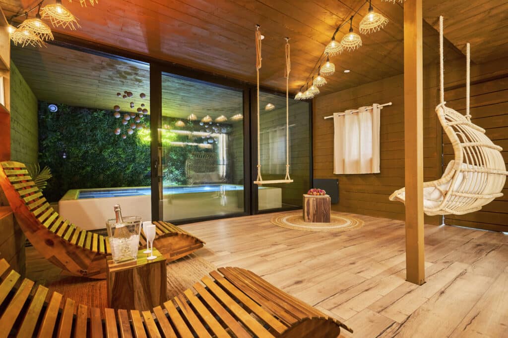 Vue d’ensemble de l’espace détente du cottage scandinave avec transats et mur végétal