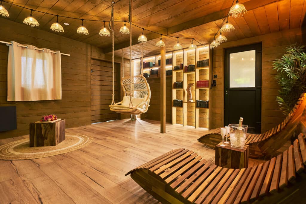 Espace détente du cottage scandinave avec fauteuil suspendu et décoration boisée