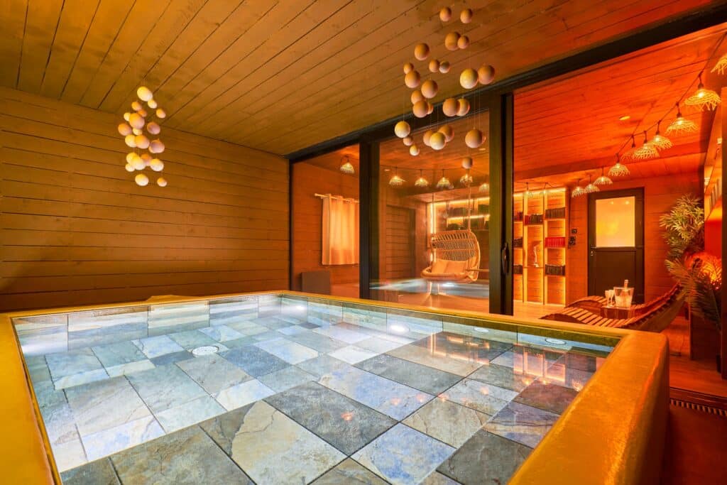 Spa intérieur du cottage Scandinave avec piscine chauffée et éclairage rouge