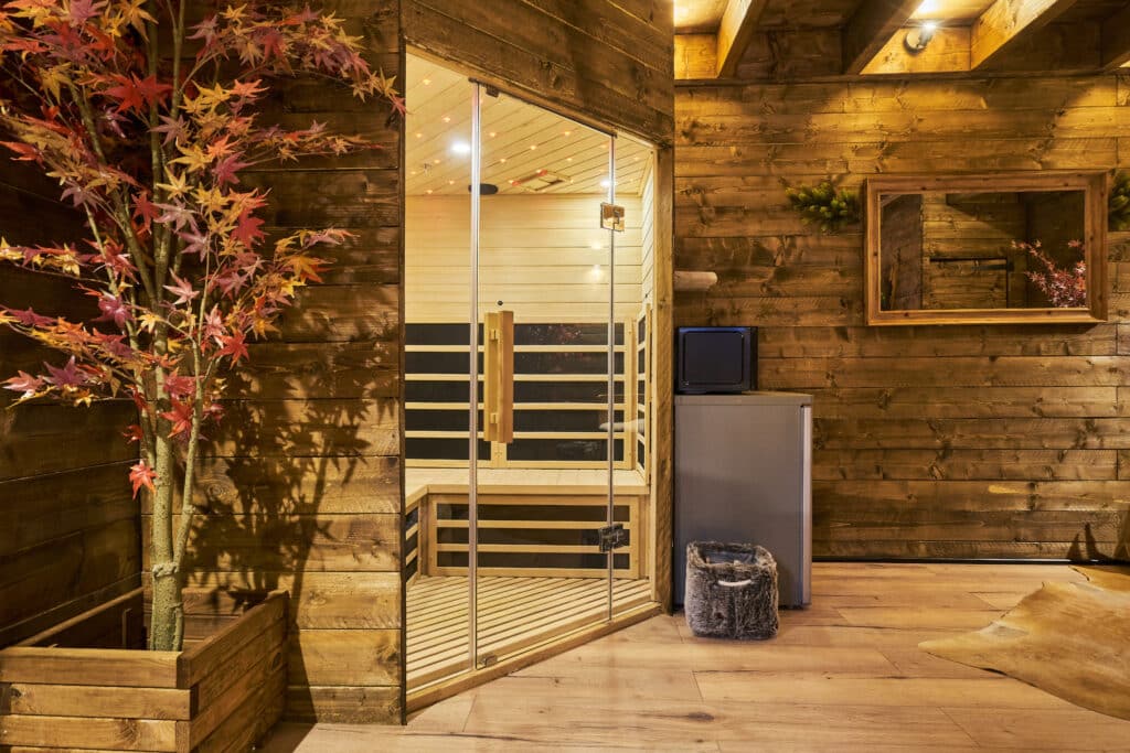 Coin détente du cottage Courchevel avec sauna vitré et décoration bois
