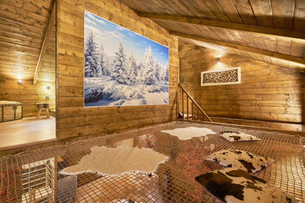 Espace détente du cottage Courchevel avec filet suspendu et tableau mural