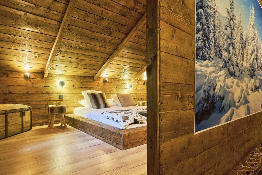 Chambre en bois du cottage Courchevel avec lit double et décoration murale