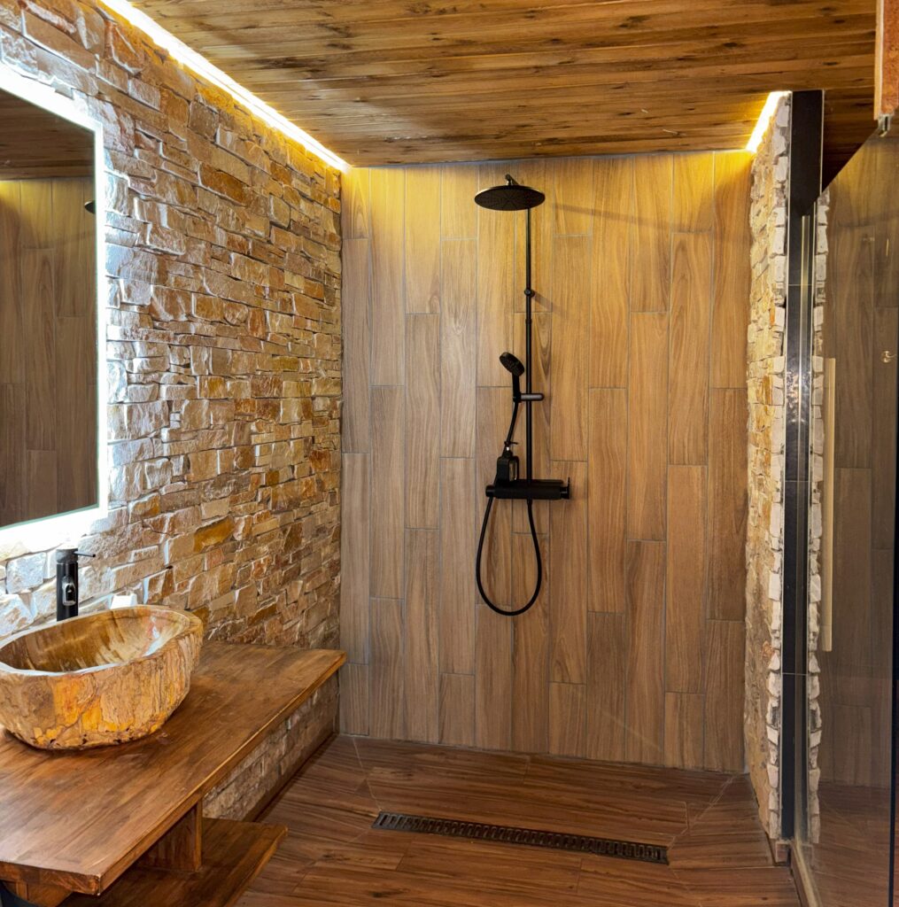 Douche italienne du cottage suédois avec mur en pierre et bois naturel