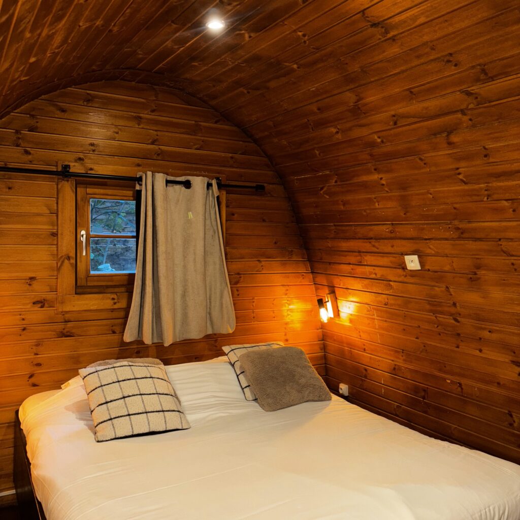 Chambre du cottage suédois avec lit double et lampe murale